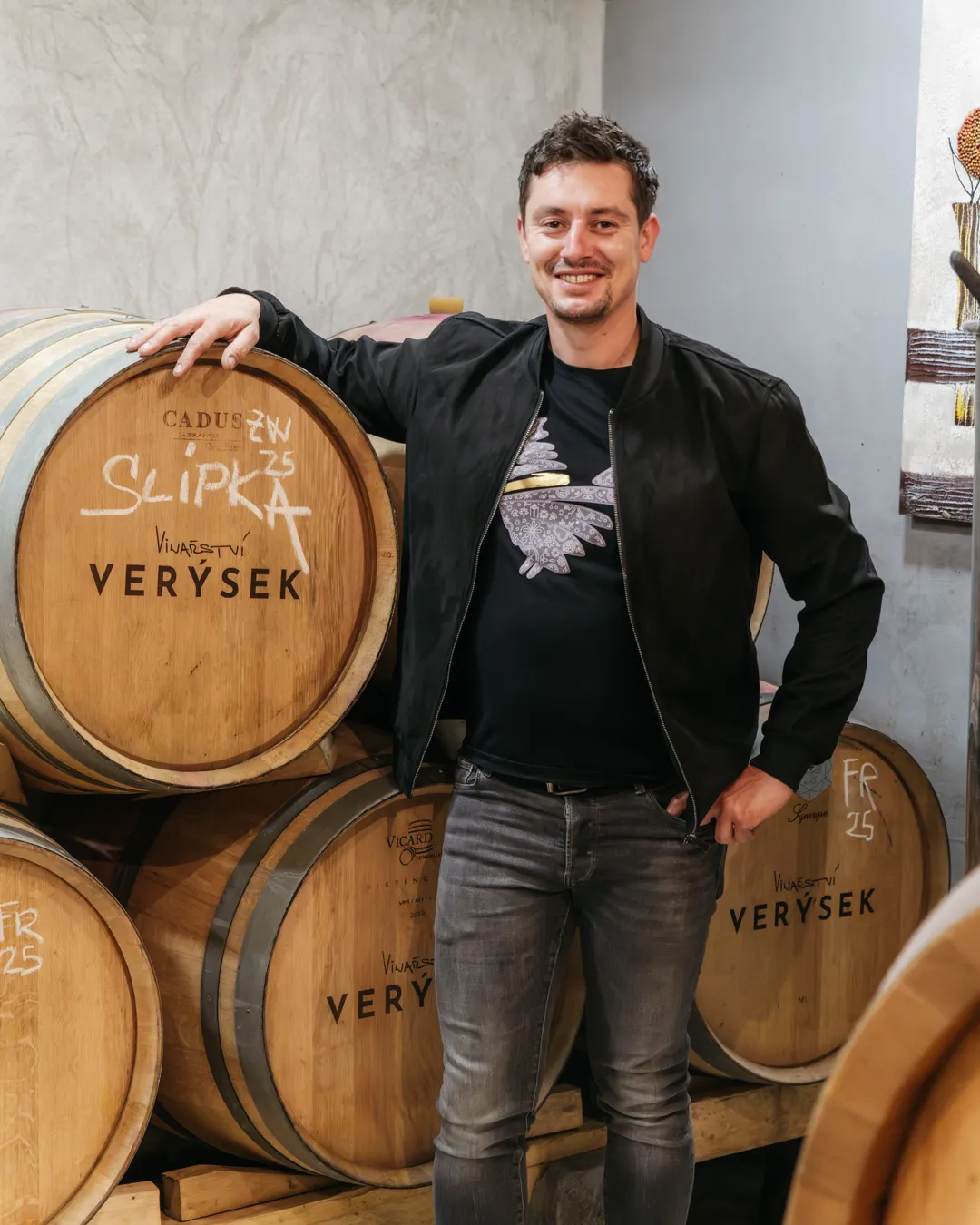 Vinař ve sklepě Vinařství Verýsek, opřený o dubový sud